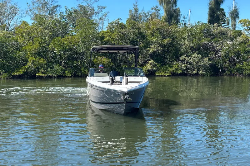 Slide: The Image of 2022 Cobalt R8 Outboard boat cruising on a calm river surrounded by lush greenery. - 2