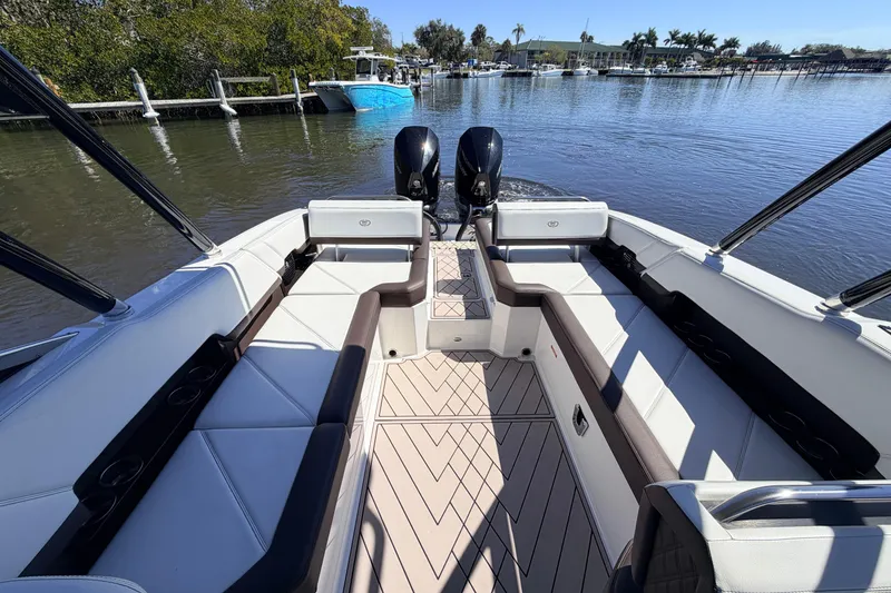 Slide: The Image of 2022 Cobalt R8 Outboard boat interior with spacious seating and dual engines on a calm waterway. - 8