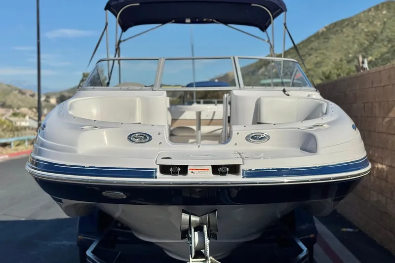 Slide: The Image of 2005 Four Winns 194 Funship boat with blue and white exterior, parked outdoors. - 2