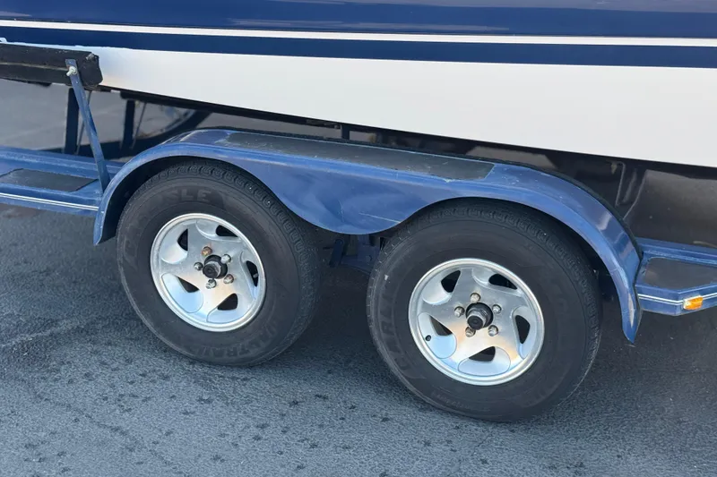 Slide: The Image of 2005 Four Winns 194 Funship trailer with dual wheels on a paved surface. - 30