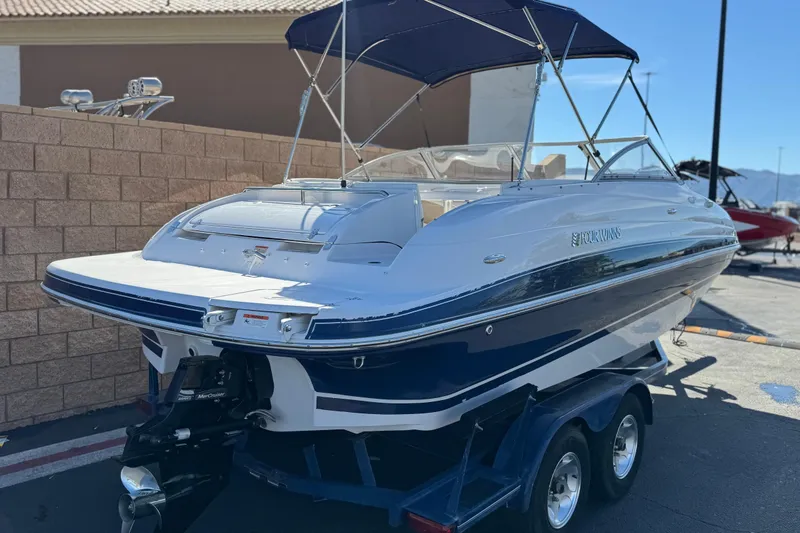 Slide: The Image of 2005 Four Winns 194 Funship boat on trailer, featuring blue and white design. - 5