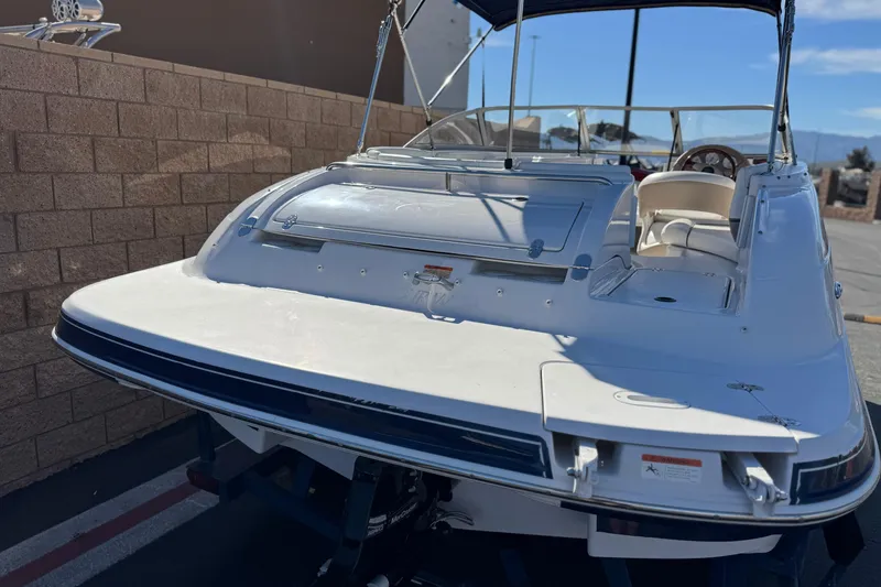 Slide: The Image of 2005 Four Winns 194 Funship boat, rear view, parked outdoors with blue canopy. - 6