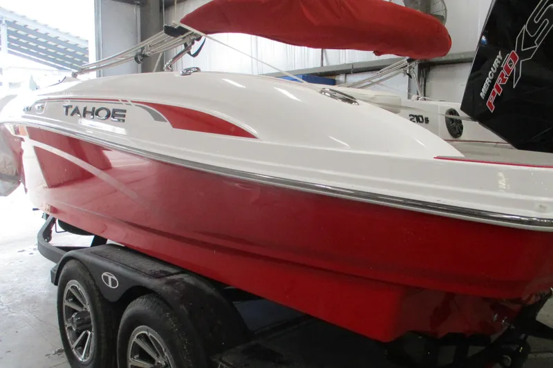 The Image of 2025 Tahoe 210 S boat with red and white design on a trailer. - 1