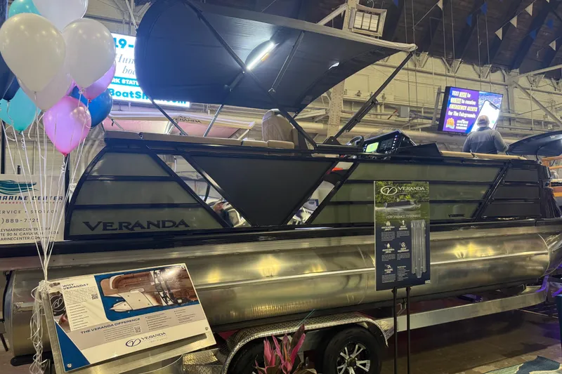 Slide: The Image of 2026 Veranda VX 235 RC pontoon boat displayed indoors with balloons and informational signage. - 11