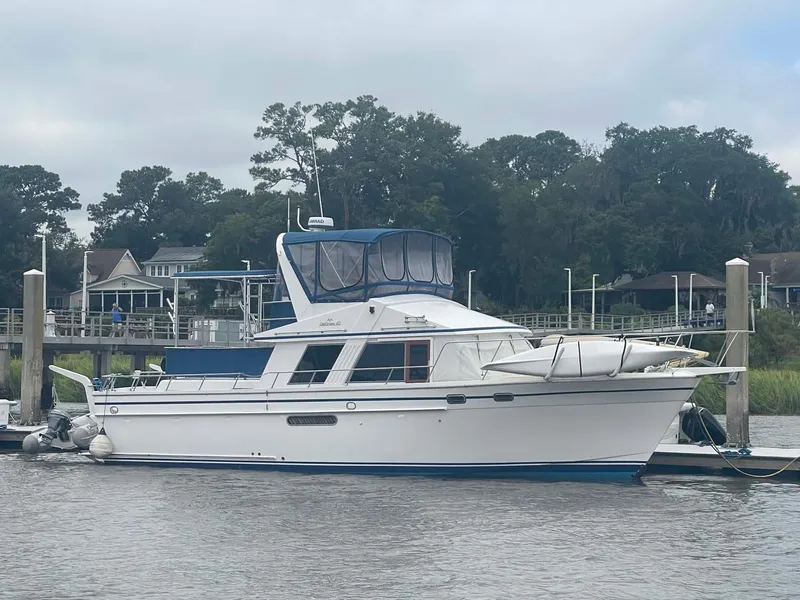 The Image of 1985 DeFever 40 Offshore Cruiser docked by a scenic waterfront. - 1