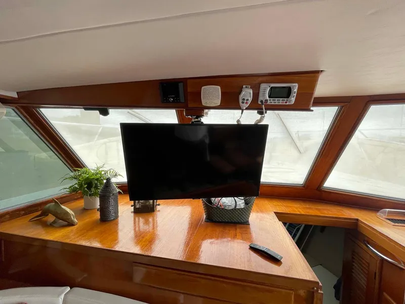 Slide: The Image of 1985 DeFever 40 Offshore Cruiser interior with TV, plants, and wooden dashboard. - 13