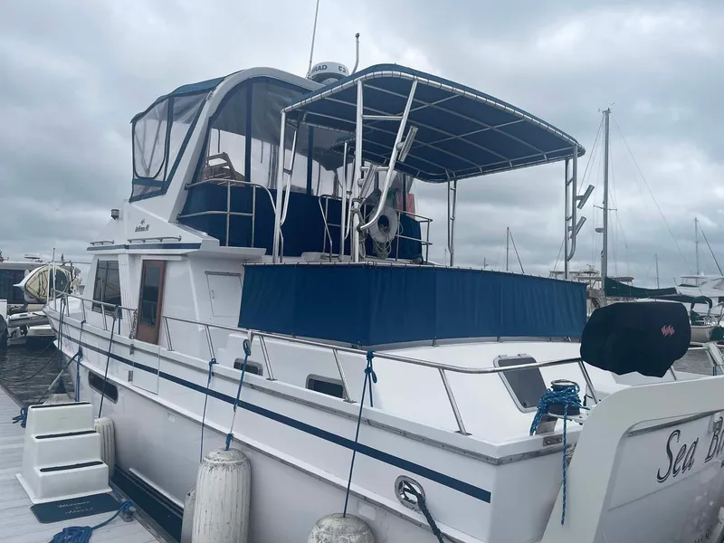 Slide: The Image of 1985 DeFever 40 Offshore Cruiser docked at marina under cloudy skies. - 4