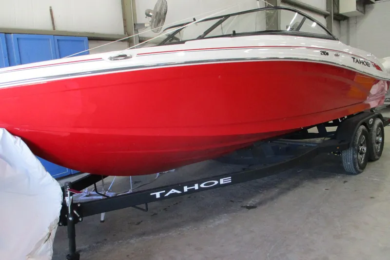 The Image of 2025 Tahoe 210 S boat in vibrant red on a trailer in a garage. - 0