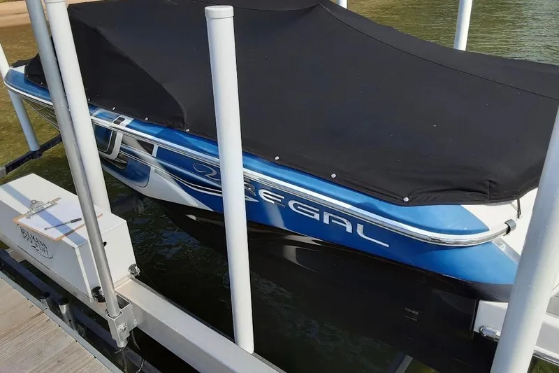 Slide: The Image of 2018 Regal 1900 ESX Bowrider with cover, docked on a lift. - 2