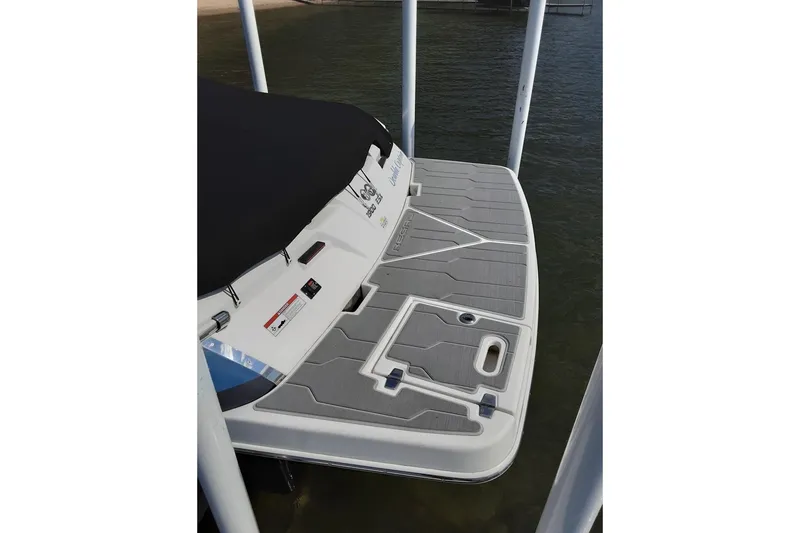 Slide: The Image of 2018 Regal 1900 ESX Bowrider boat with covered deck, docked on calm water. - 3