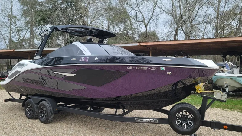 Slide: The Image of 2023 Scarab 285 ID boat parked on trailer outdoors. - 25