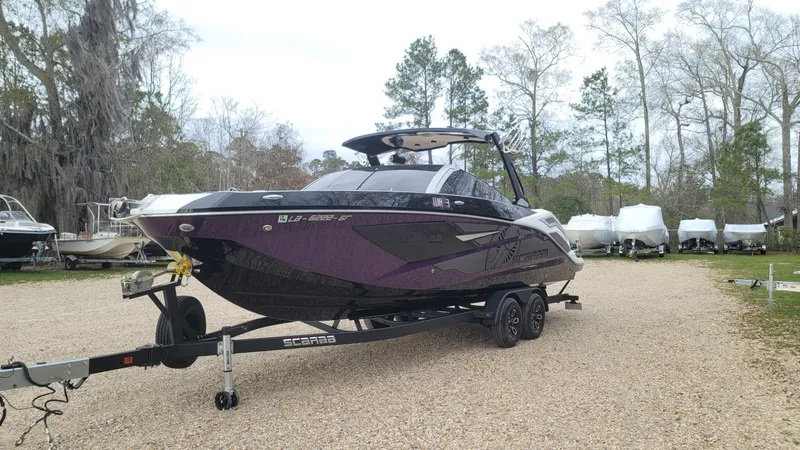 Slide: The Image of 2023 Scarab 285 ID boat parked on trailer outdoors. - 6