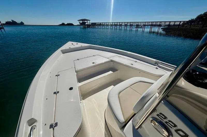 Slide: The Image of 2025 Bulls Bay 2200 XS boat on serene water with dock in background. - 12