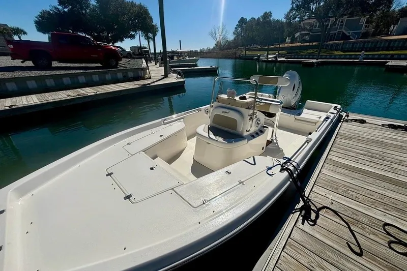 Slide: The Image of 2025 Bulls Bay 2200 XS boat docked at a marina under clear skies. - 3