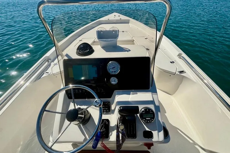 Slide: The Image of 2025 Bulls Bay 2200 XS boat dashboard with steering wheel and controls on open water. - 7