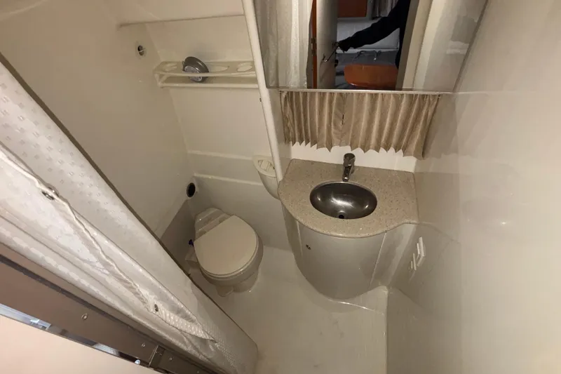 Slide: The Image of 2005 Formula 31 Performance Cruiser bathroom with sink, toilet, and shower curtain. - 40