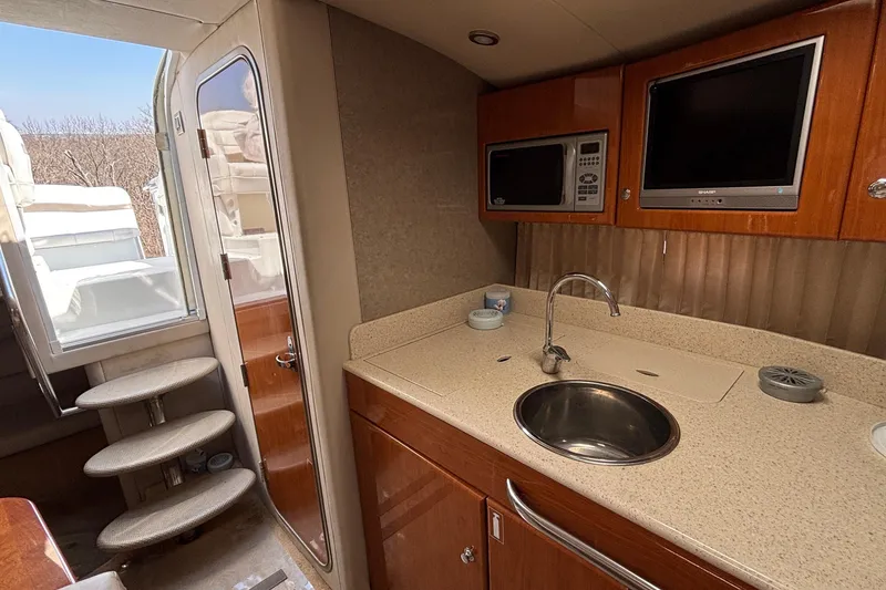 Slide: The Image of 2005 Formula 31 Performance Cruiser interior with kitchenette, sink, microwave, and TV. - 52