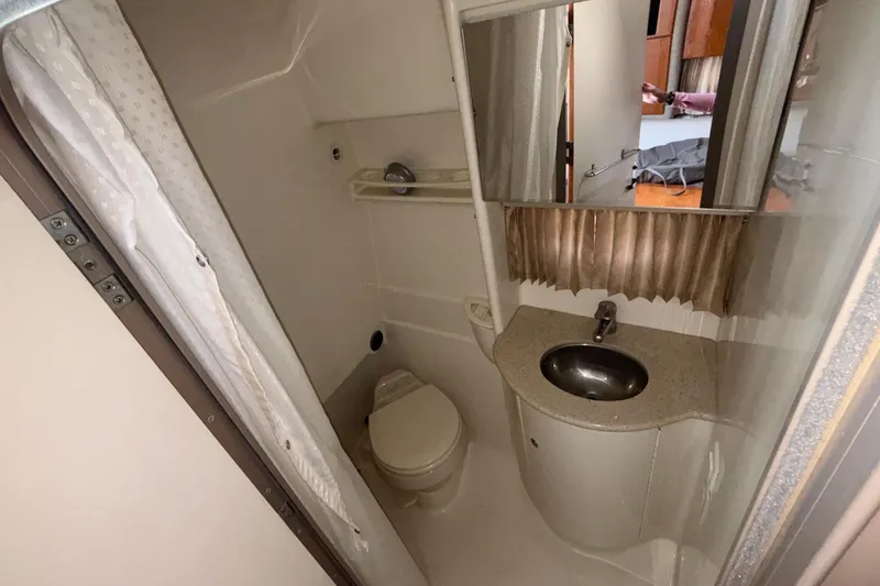 Slide: The Image of Compact bathroom in a 2005 Formula 31 Performance Cruiser, featuring a sink, toilet, and shower. - 54