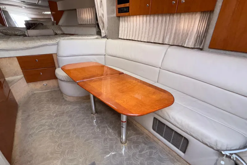 Slide: The Image of Interior of a 2005 Formula 31 Performance Cruiser with a wooden table and white seating. - 61