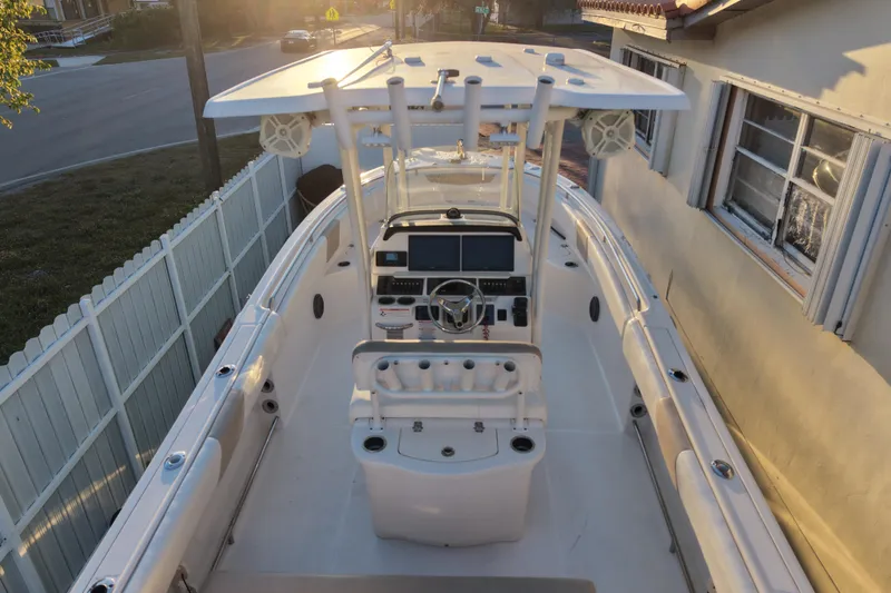 Slide: The Image of 2018 Robalo R242 Center Console boat, top view, parked beside a house at sunset. - 10