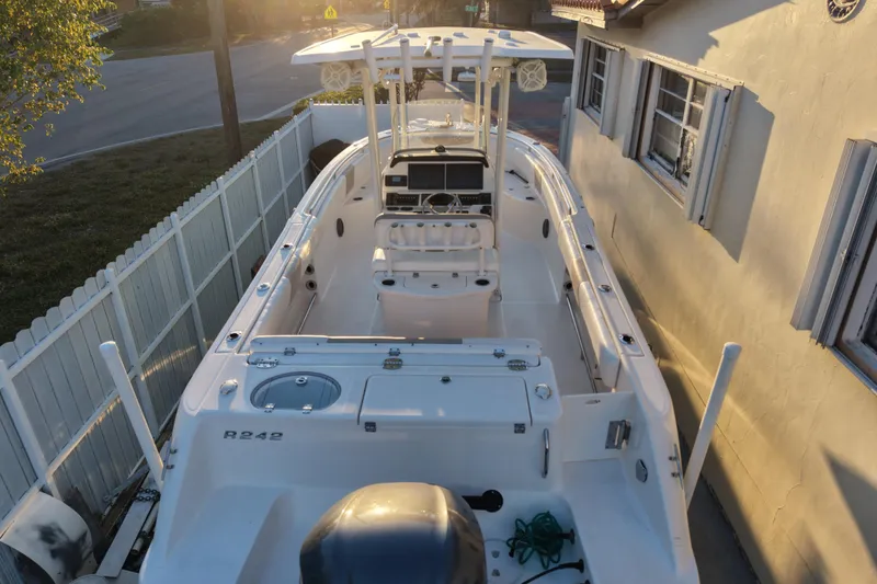 Slide: The Image of 2018 Robalo R242 Center Console boat docked in a residential area at sunset. - 11