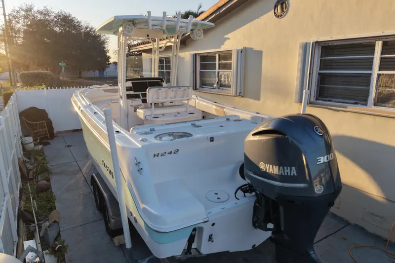 Slide: The Image of 2018 Robalo R242 Center Console boat with Yamaha 300 engine, parked beside a house. - 12