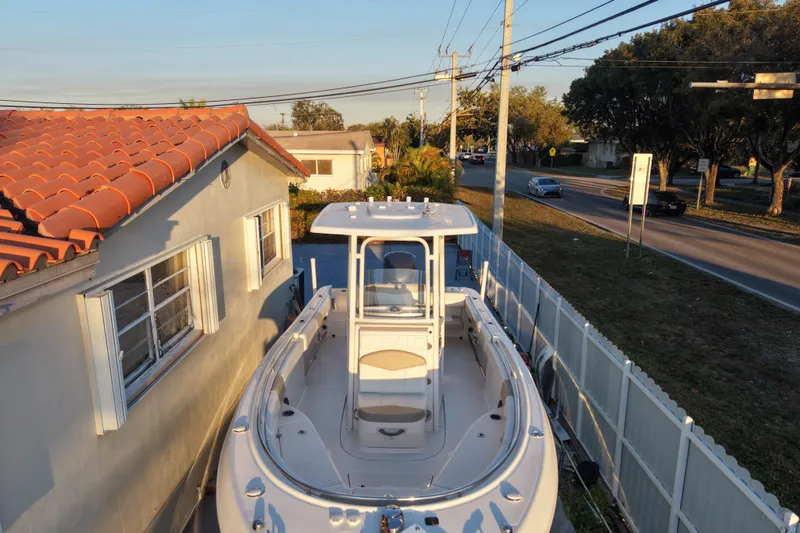 Slide: The Image of 2018 Robalo R242 Center Console boat parked beside a house on a sunny day. - 13