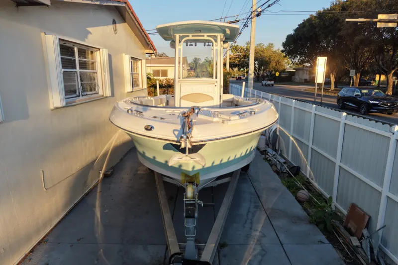 Slide: The Image of 2018 Robalo R242 Center Console boat on trailer beside house. - 15