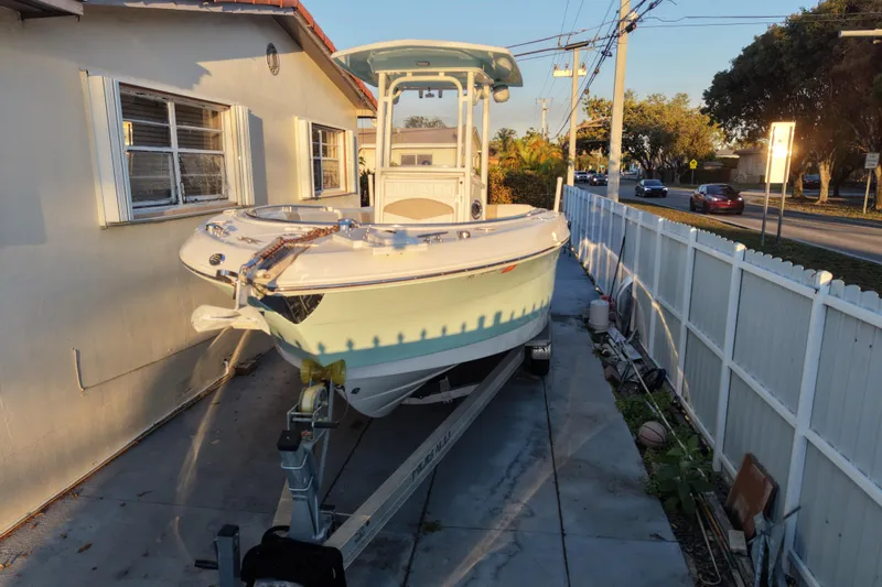 Slide: The Image of 2018 Robalo R242 Center Console boat on trailer beside house. - 16