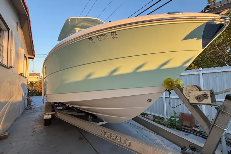 Slide: The Image of 2018 Robalo R242 Center Console boat on trailer in driveway. - 17