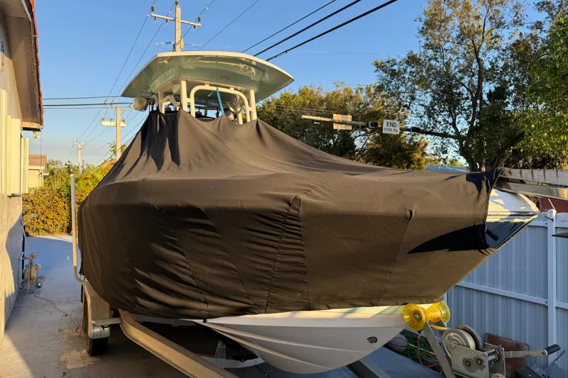 Slide: The Image of 2018 Robalo R242 Center Console boat covered on trailer, parked outdoors. - 20