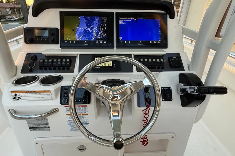 Slide: The Image of 2018 Robalo R242 Center Console dashboard with steering wheel and navigation screens. - 25