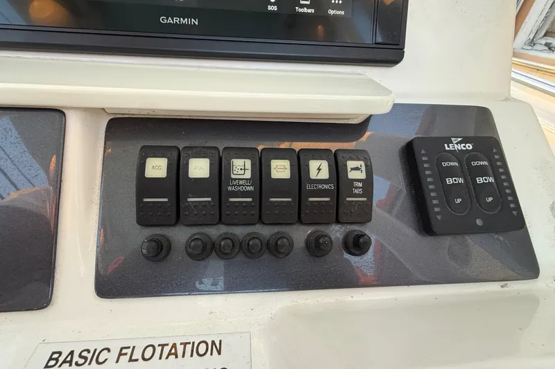 Slide: The Image of Control panel of 2018 Robalo R242 Center Console boat with switches and Lenco trim tab controls. - 29