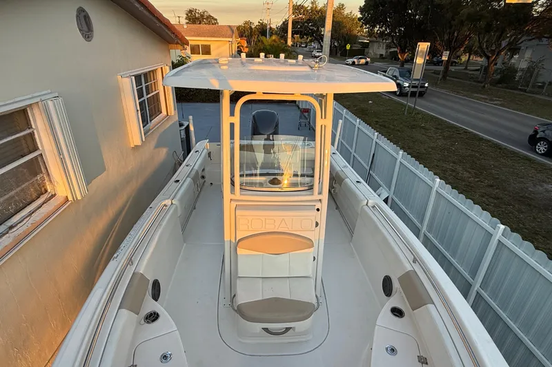 Slide: The Image of 2018 Robalo R242 Center Console boat docked beside a house at sunset. - 31