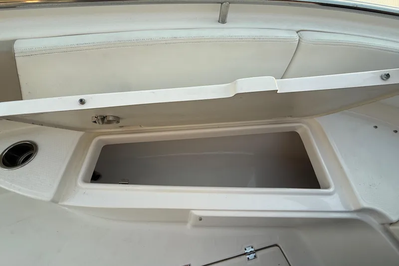 Slide: The Image of 2018 Robalo R242 Center Console boat storage compartment open, showing interior space. - 33