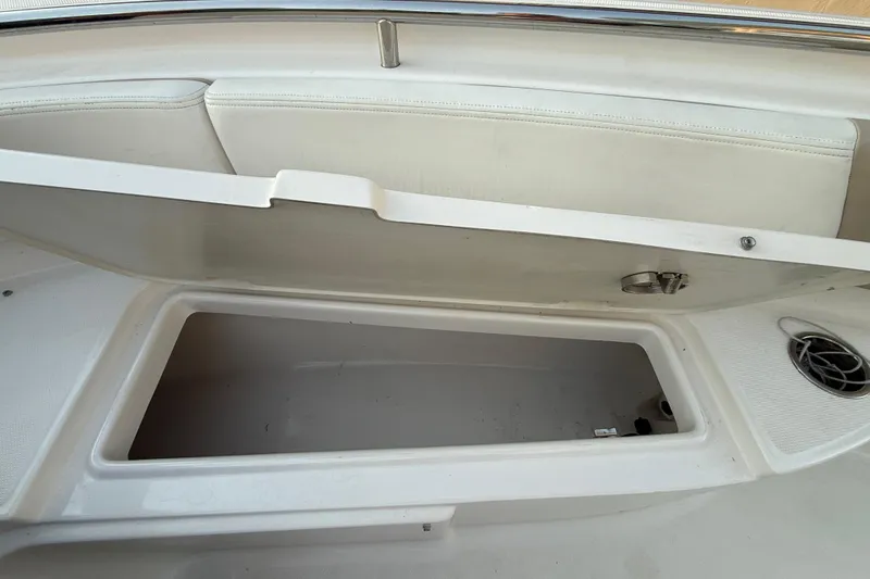Slide: The Image of 2018 Robalo R242 Center Console boat storage compartment open, showcasing interior space. - 34