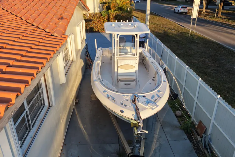 Slide: The Image of 2018 Robalo R242 Center Console boat parked beside a house. - 4