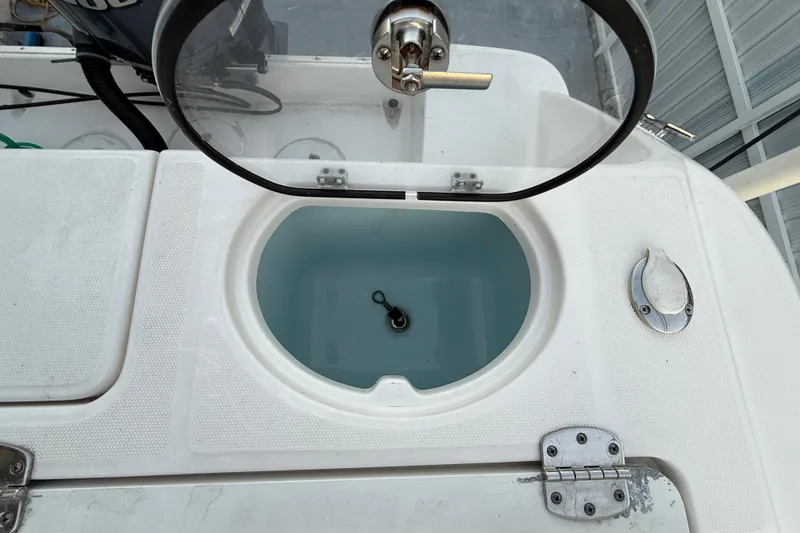 Slide: The Image of 2018 Robalo R242 Center Console livewell with open lid, showcasing interior details. - 44