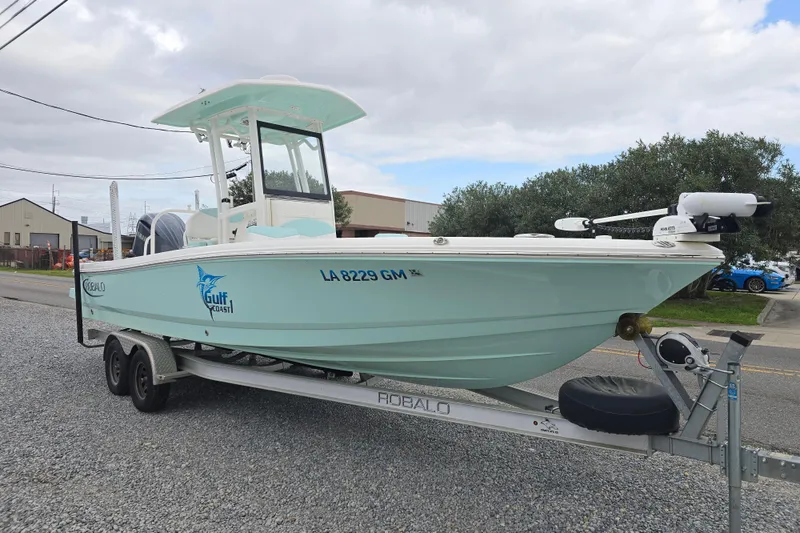Slide: The Image of 2021 Robalo 246 Cayman boat on trailer, light blue, parked outdoors. - 1