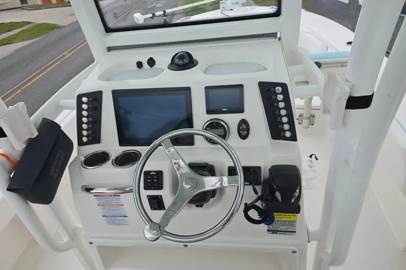 Slide: The Image of 2021 Robalo 246 Cayman boat dashboard with steering wheel and electronic controls. - 10