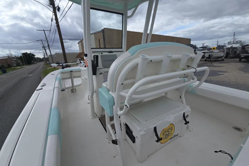 Slide: The Image of 2021 Robalo 246 Cayman boat interior with seating and storage, parked on a street. - 11