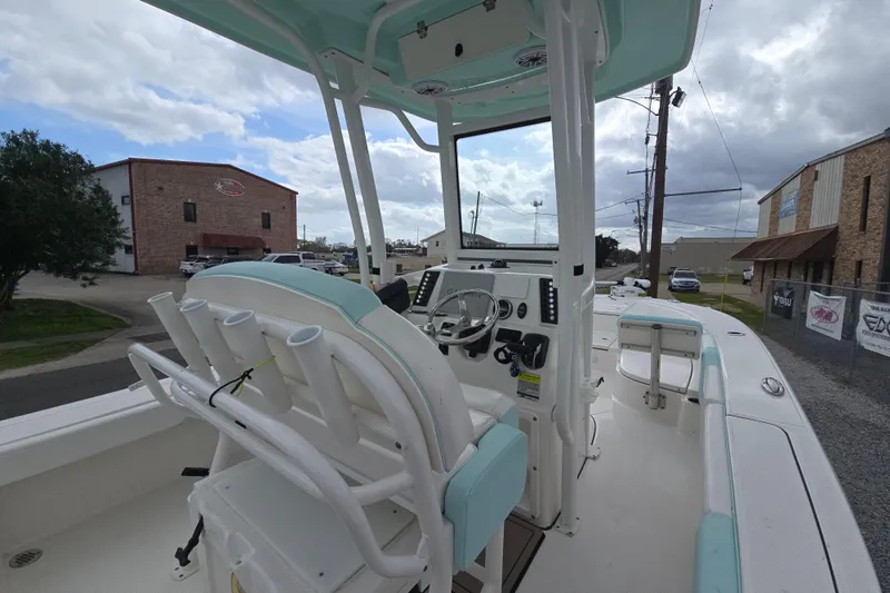 Slide: The Image of 2021 Robalo 246 Cayman boat interior with steering console and rod holders. - 12
