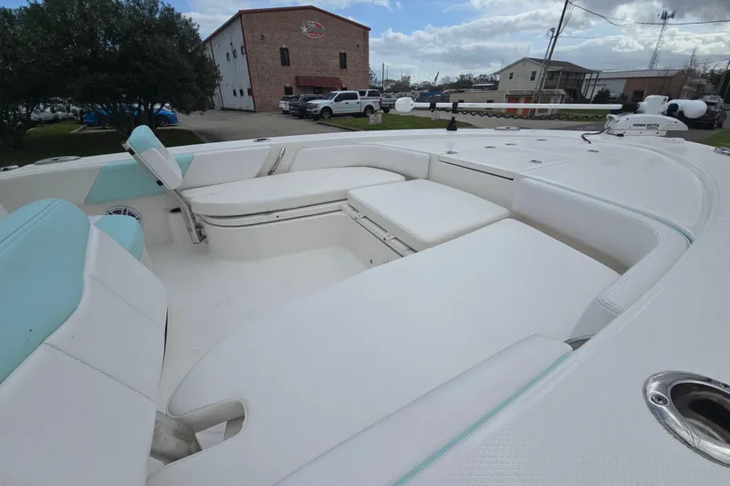Slide: The Image of 2021 Robalo 246 Cayman boat interior with white seating and open deck layout. - 14