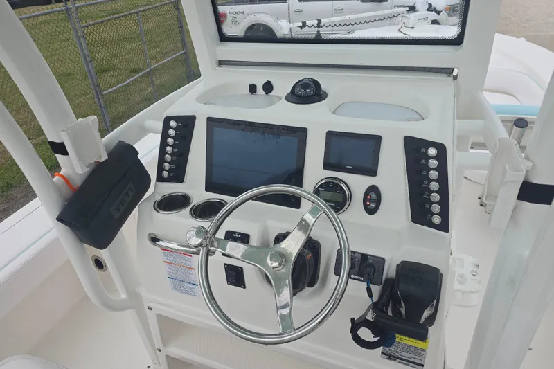Slide: The Image of 2021 Robalo 246 Cayman boat dashboard with steering wheel and electronic controls. - 18