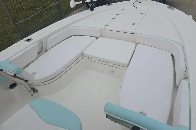 Slide: The Image of 2021 Robalo 246 Cayman boat interior with white and teal seating arrangement. - 19
