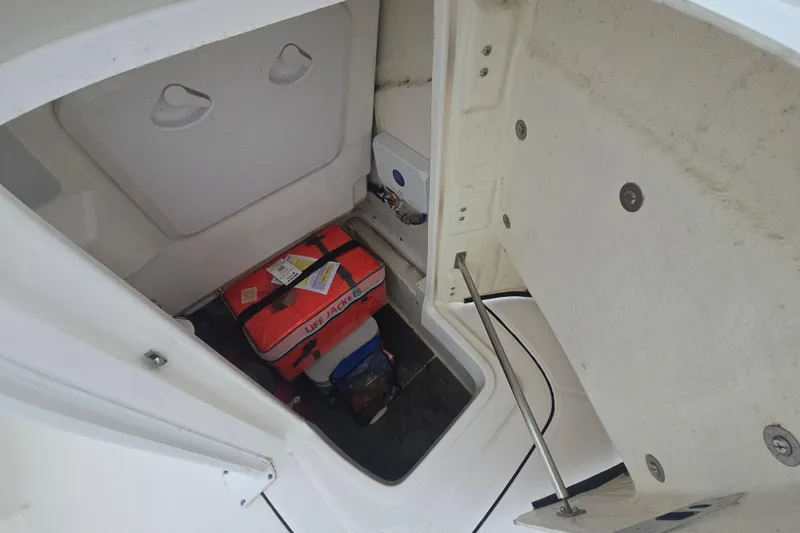 Slide: The Image of 2021 Robalo 246 Cayman storage compartment with life jackets and equipment. - 21