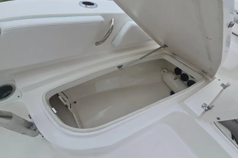Slide: The Image of 2021 Robalo 246 Cayman boat storage compartment open, showcasing interior space. - 23