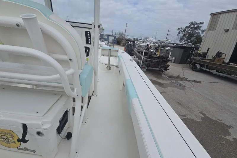 Slide: The Image of 2021 Robalo 246 Cayman boat interior with seating and console, docked in a marina. - 25