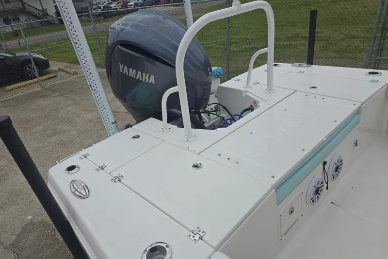 Slide: The Image of 2021 Robalo 246 Cayman boat with Yamaha outboard motor, docked in a fenced area. - 29