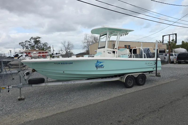 Slide: The Image of 2021 Robalo 246 Cayman boat on trailer, parked outdoors, overcast sky. - 5